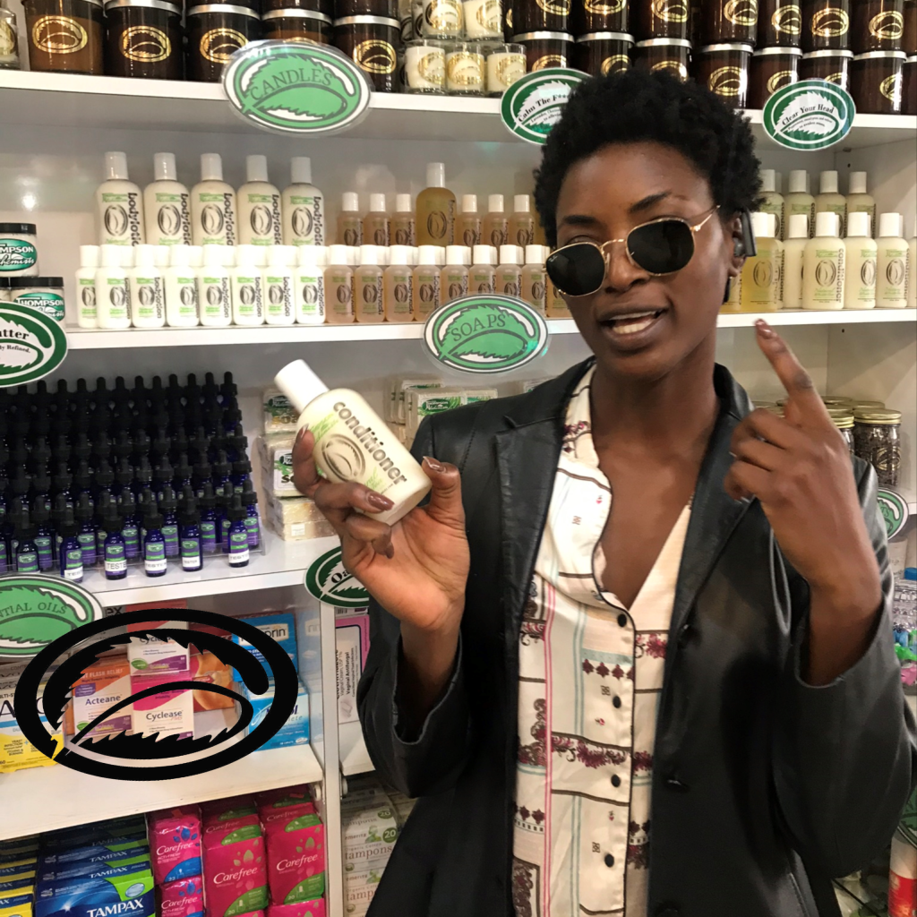 a picture of a woman holding a bottle of thompson alchemists hair conditioner at thompson chemists nyc 